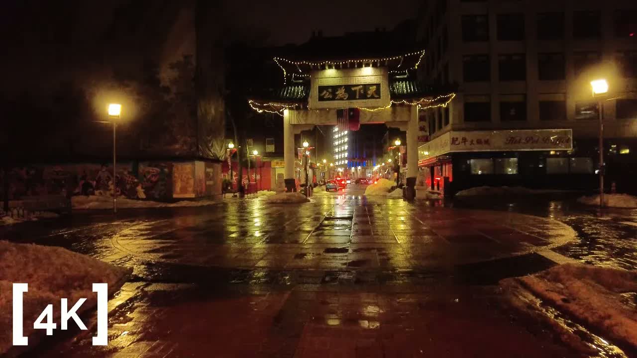 Boston Chinatown at 2 a.m. in rain: the gate arch strung with lights above wet pavement and banks of old snow.
