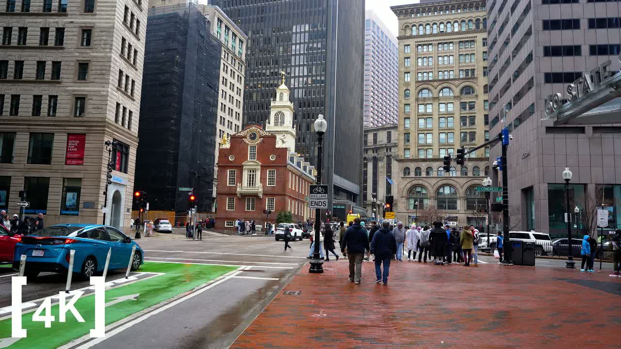 Downtown Boston by day after a rainstorm: the Old State House's brick gable and white tower ringed by office towers.