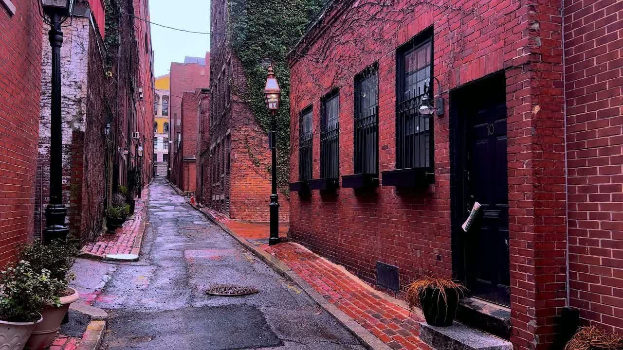 Beacon Hill, Boston at daytime in spring rain: a gas lamp beside a black door numbered 10 on a wet brick lane.