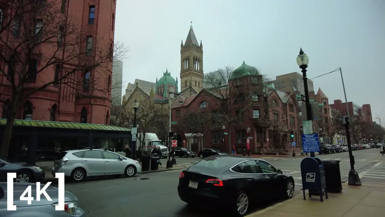 Newbury Street, Boston at early morning in fog: a stone church tower rising over bare trees into a gray sky